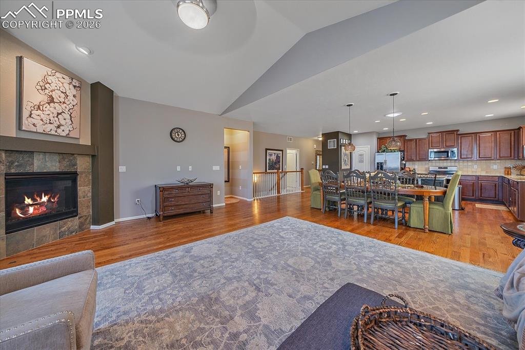 Image 6 of 47: Living room with light wood-style floors, recessed lighting, a tiled firepl