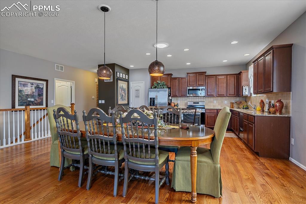 Image 8 of 47: Dining space with light wood-style floors and recessed lighting