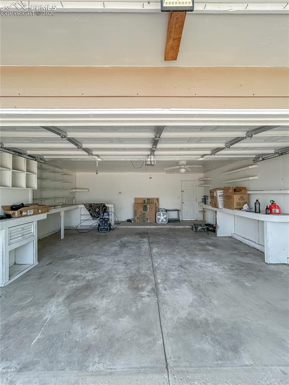 Image 20 of 28: Garage; Spacious two-car garage with built-in shelving, workbench space, an