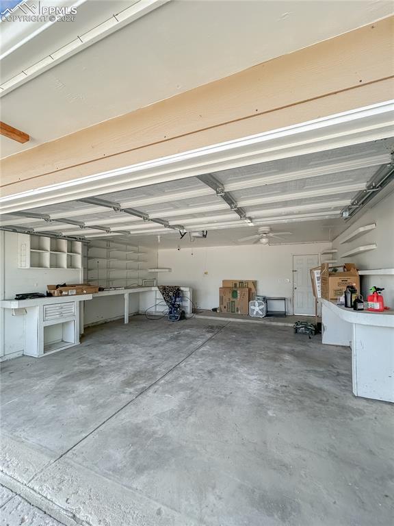 Image 21 of 28: Garage; Spacious two-car garage with built-in shelving, workbench space, an