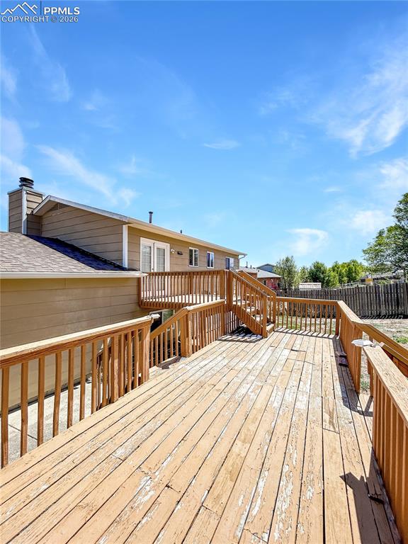 Image 22 of 28: Deck; Spacious multi-level wooden deck with railings and stairs leading to 