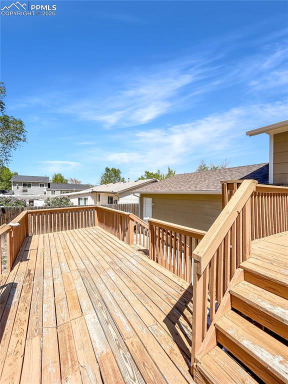 Image 23 of 28: Deck; Spacious multi-level wooden deck with railings and stairs leading to 