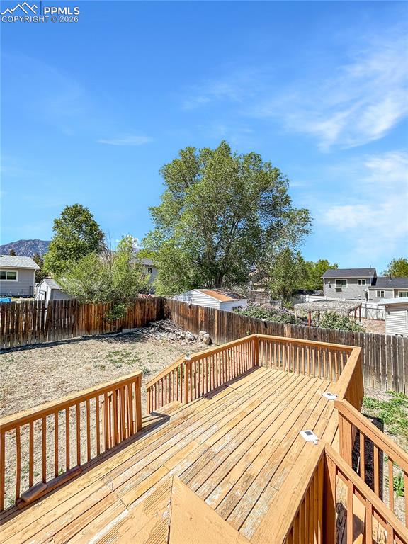 Image 24 of 28: Deck; Spacious multi-level wooden deck with railings and stairs leading to 