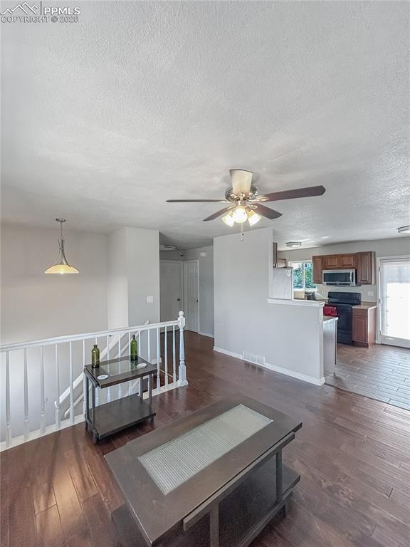 Image 3 of 28: Living Room; Open living room with dark wood floors, neutral walls, a ceili
