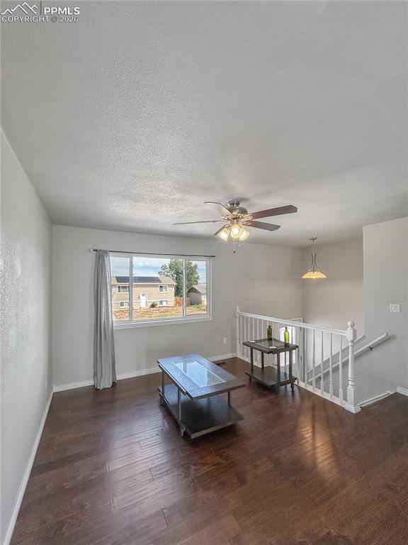 Image 4 of 28: Living Room; Open living room with dark wood floors, neutral walls, a ceili