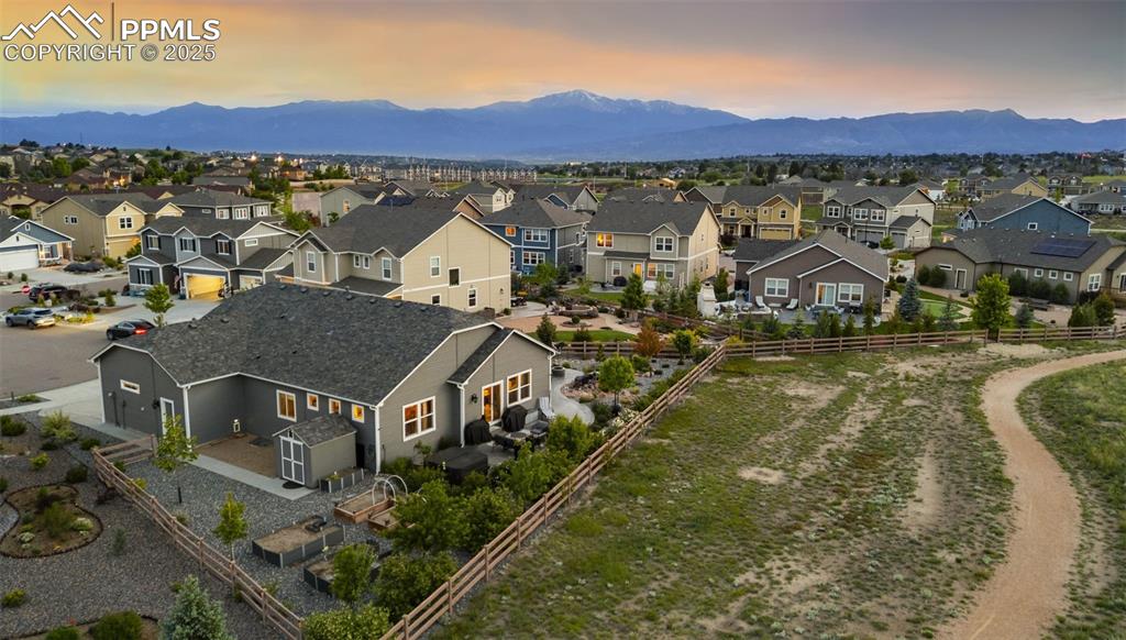 Image 33 of 50: Open space behind the home features a walking path