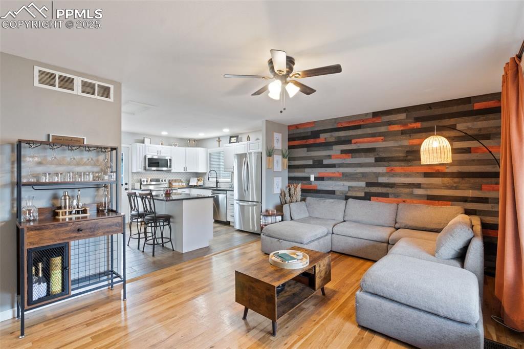 Image 3 of 34: OPEN LIVING ROOM WITH TRI COLOR WOOD ACCENT WALL