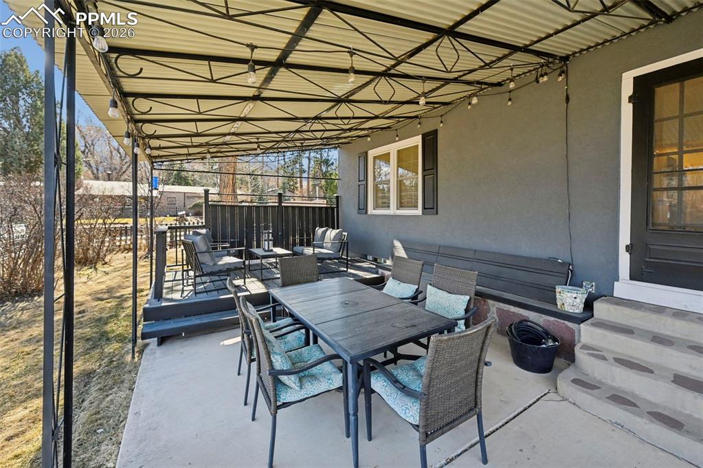 Image 8 of 48: Outdoor covered patio dining off of formal dining room french doors
