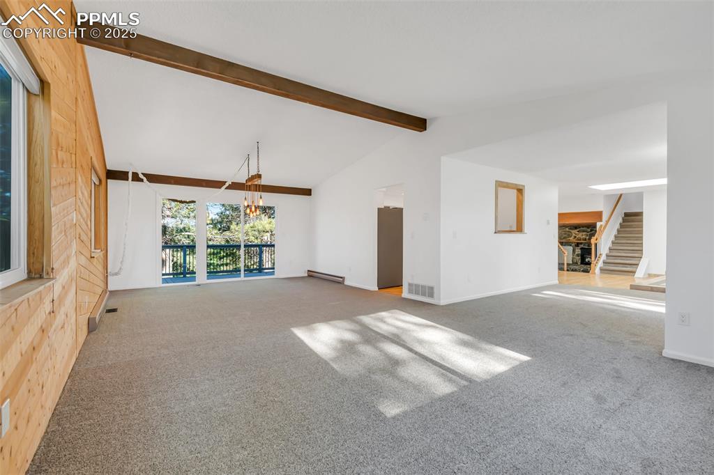 Image 13 of 46: Unfurnished living room featuring carpet, stairway, and a baseboard radiato