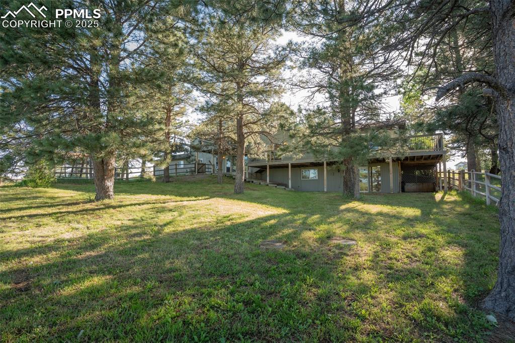 Image 2 of 46: Fenced backyard with a wooden deck