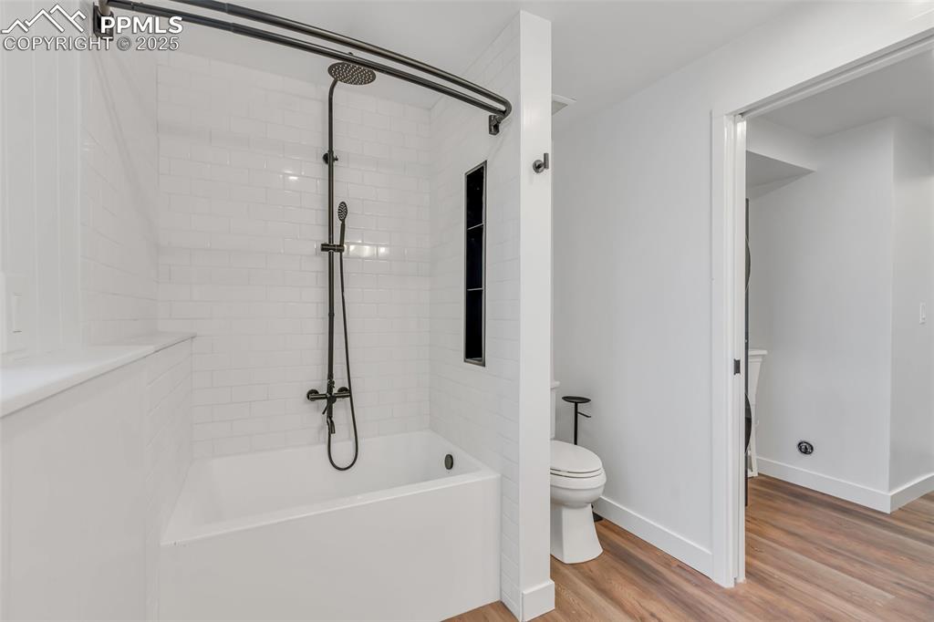 Image 22 of 46: Bathroom featuring wood finished floors and shower / washtub combination