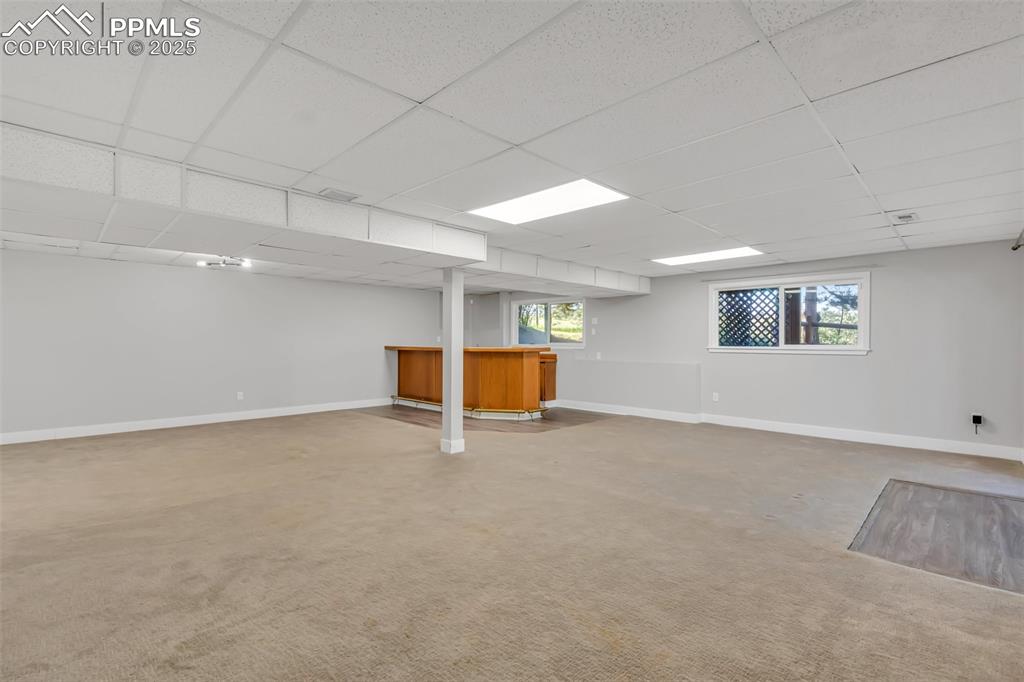 Image 39 of 46: Below grade area featuring a drop ceiling, a dry bar, healthy amount of nat