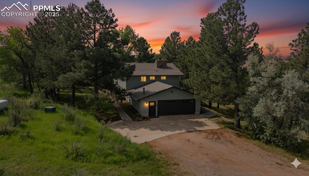 Image 41 of 46: View of front of home featuring driveway, a garage, and a chimney