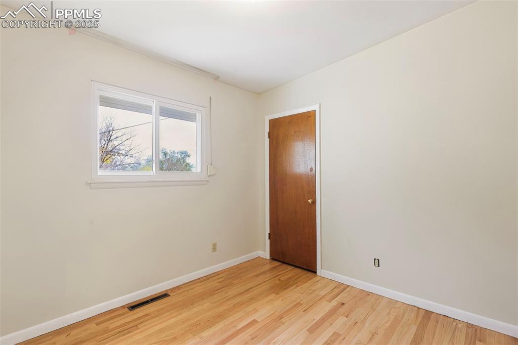 Image 12 of 35: Spare room with baseboards and light wood finished floors
