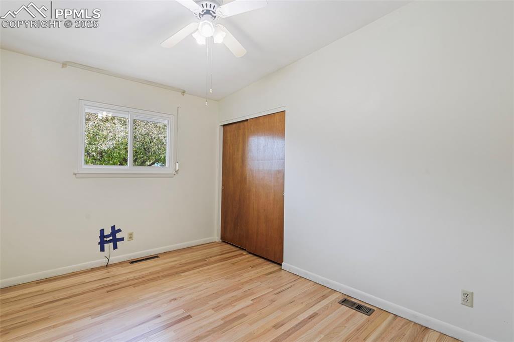 Image 13 of 35: Unfurnished bedroom with wood finished floors, a closet, and ceiling fan