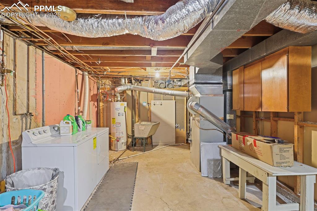Image 26 of 35: Unfinished basement featuring washer and dryer, gas water heater, and heati