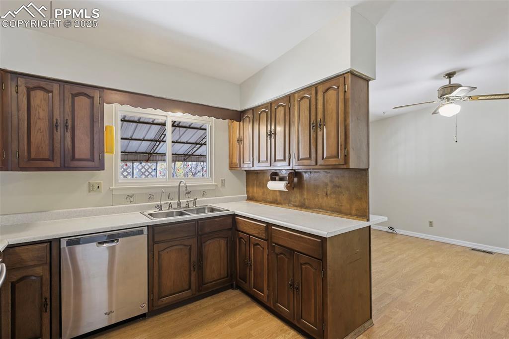 Image 8 of 35: Kitchen featuring light countertops, stainless steel dishwasher, light wood
