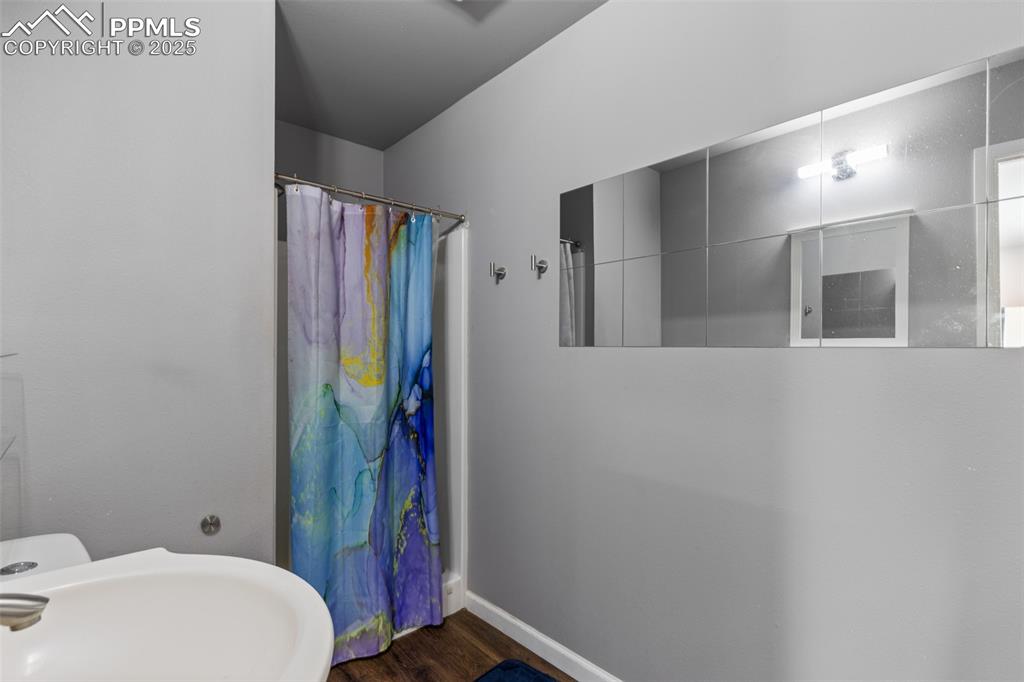 Image 27 of 36: Full bathroom featuring a shower stall and dark wood-style flooring