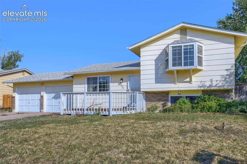 Image 1 of 38: Split-level residence featuring a two-car garage, front deck, and bay windo