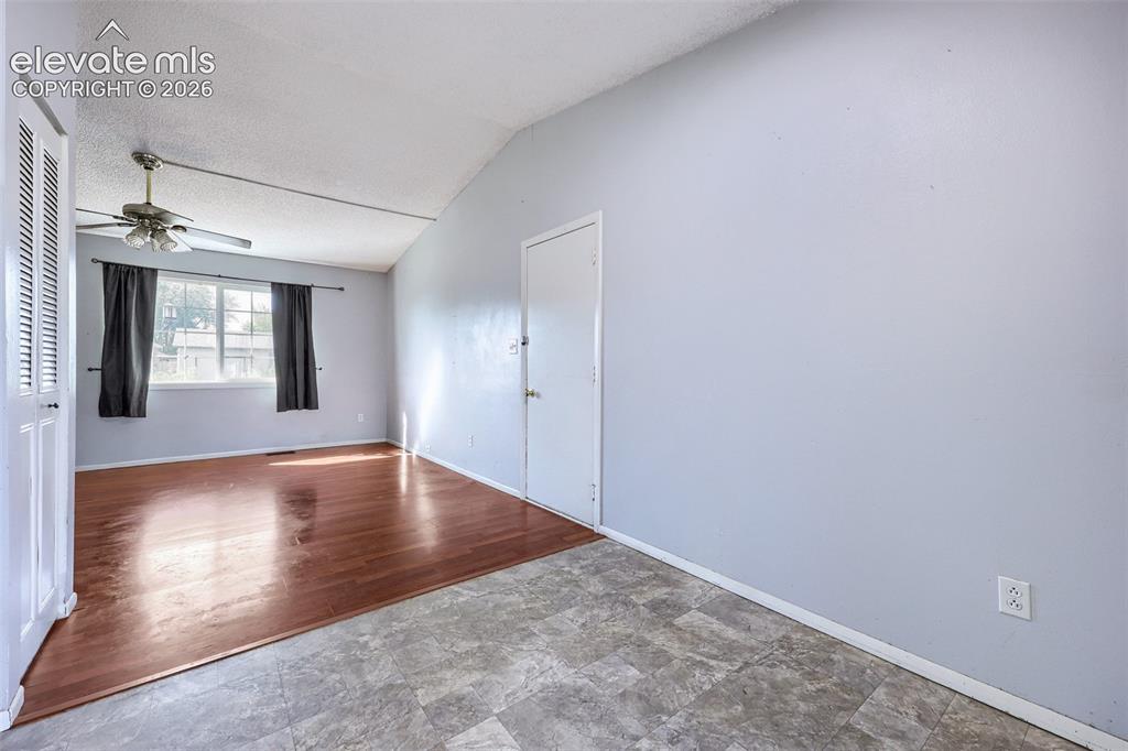 Image 12 of 38: Spacious room featuring wood-finish flooring, a vaulted ceiling, and a ceil