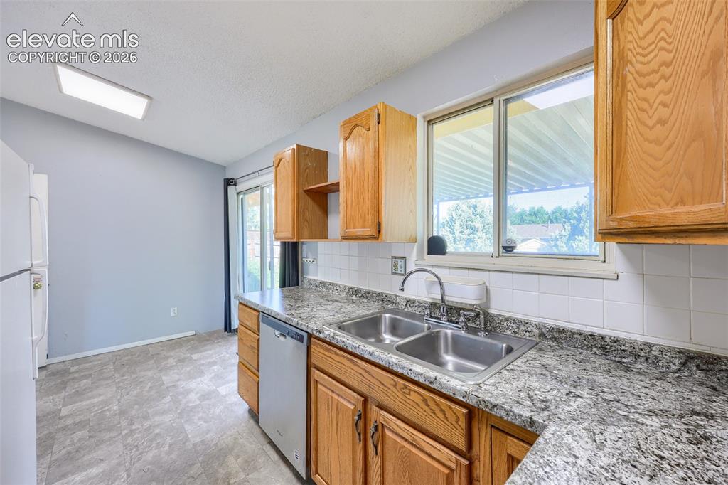 Image 14 of 38: Kitchen featuring wood cabinetry, a stainless steel double basin sink, and 