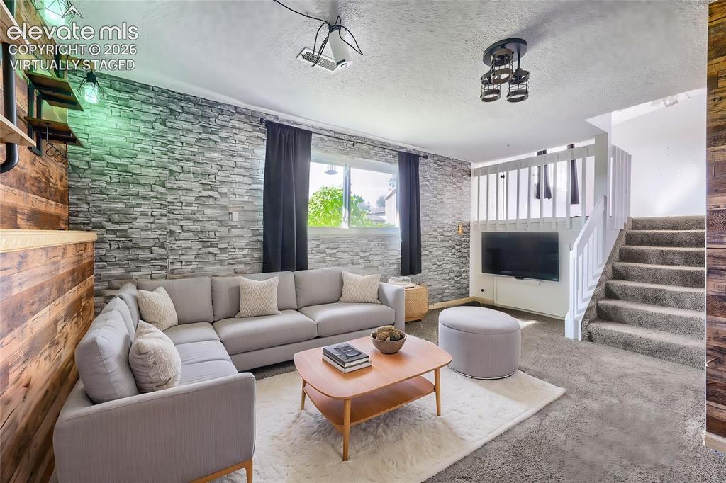 Image 18 of 38: Virtually Staged - Versatile family area featuring a stacked stone accent w