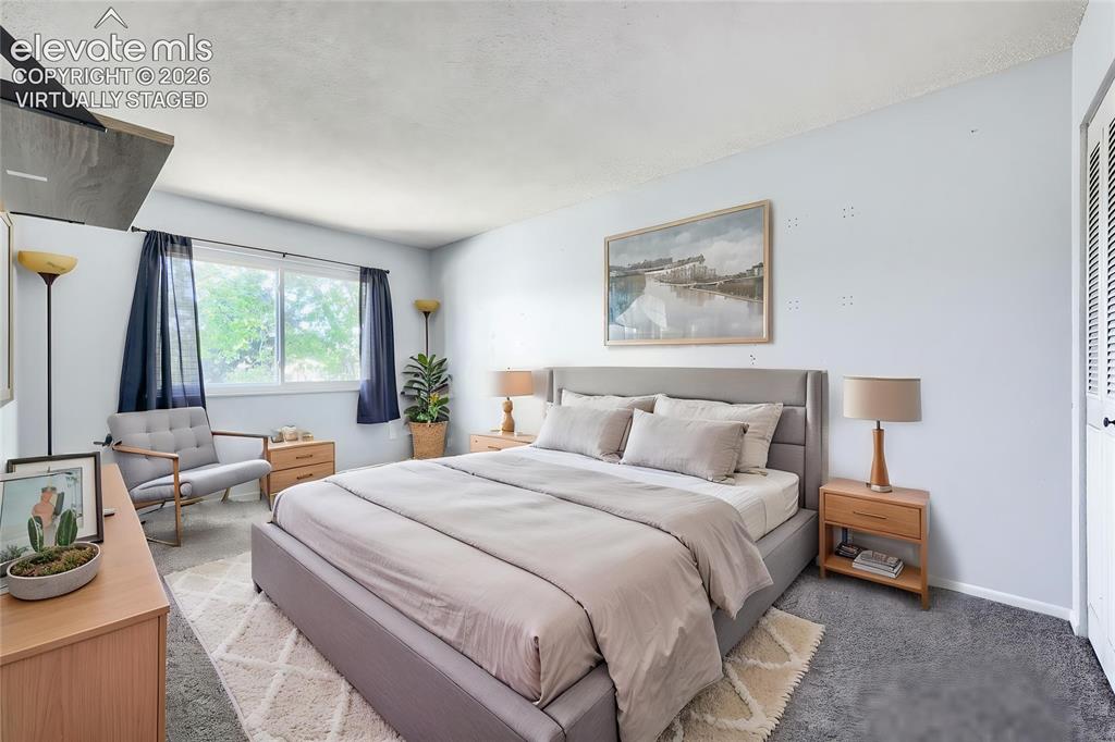 Image 21 of 38: Virtually Staged - Spacious bedroom featuring light blue walls, gray carpet