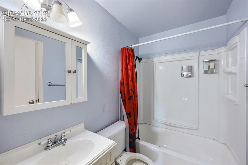 Image 24 of 38: Bathroom featuring a white vanity with an integrated sink, a polished chrom
