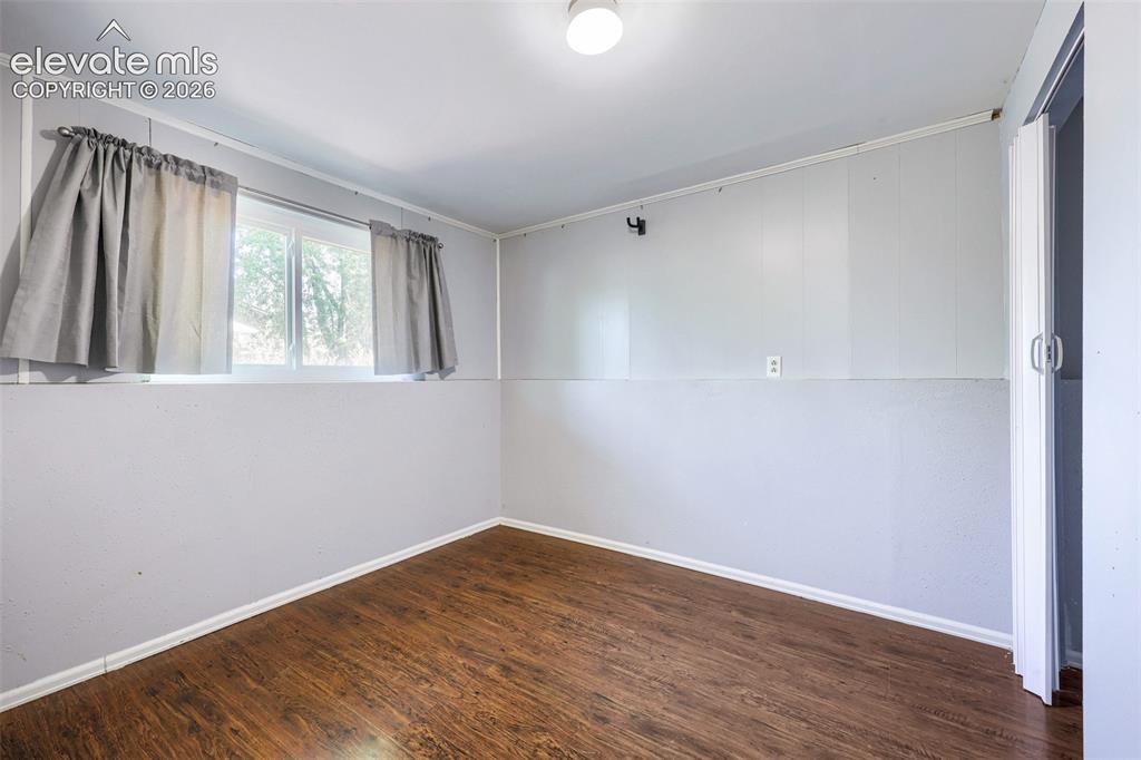 Image 25 of 38: Room featuring wood-finish flooring, light grey paneling, a ceiling-mounted
