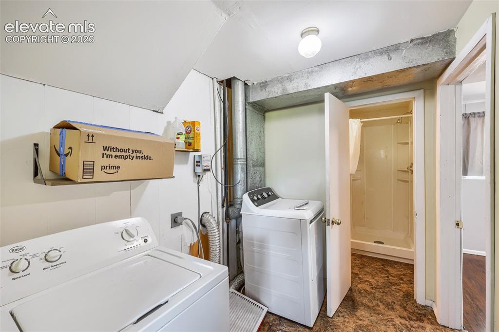 Image 30 of 38: Utility area featuring a top-load washing machine, built-in shelving, a ful