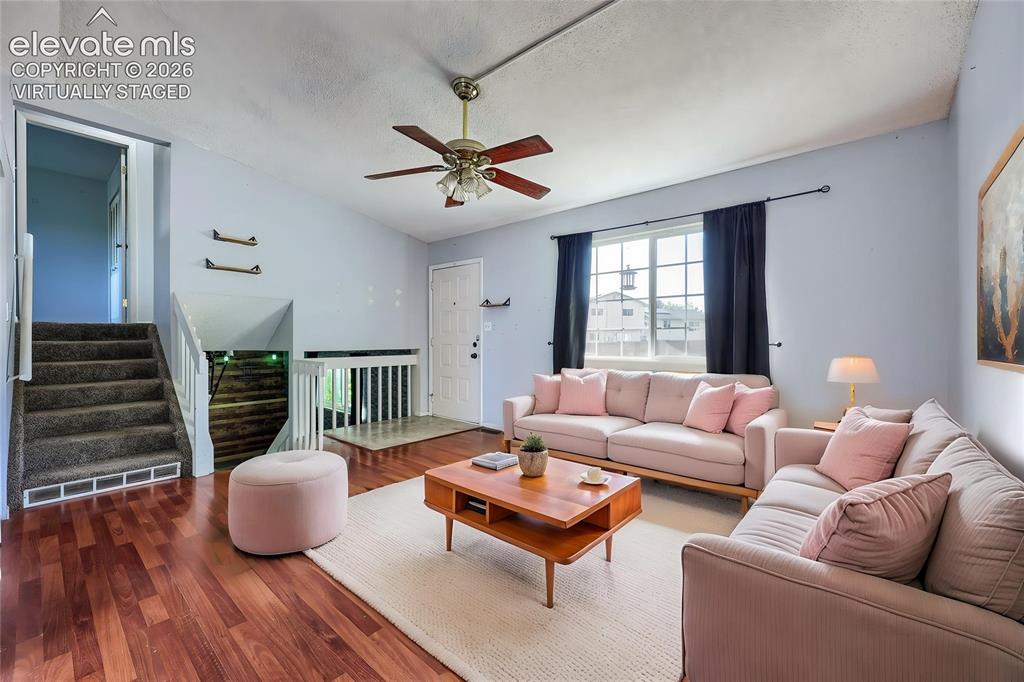 Image 5 of 38: Virtually Staged Spacious room featuring vaulted ceilings, wood-finish floo