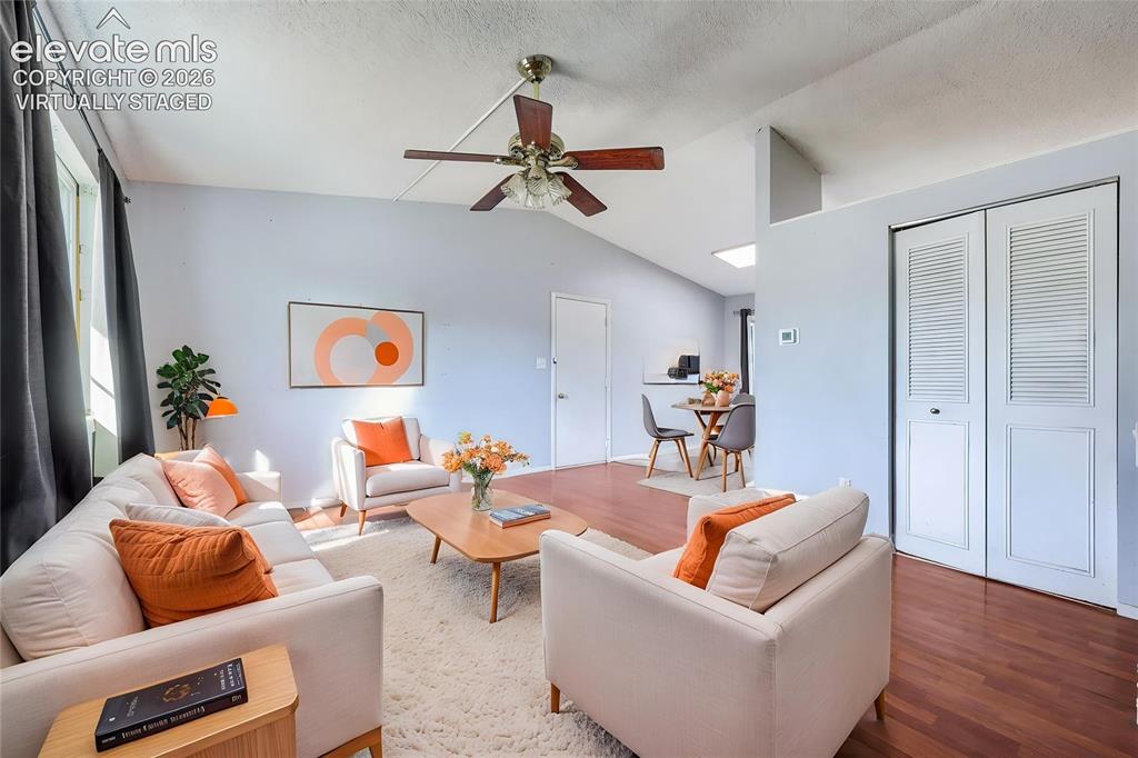Image 9 of 38: Virtually Staged - Living area featuring vaulted ceilings, wood-finish floo