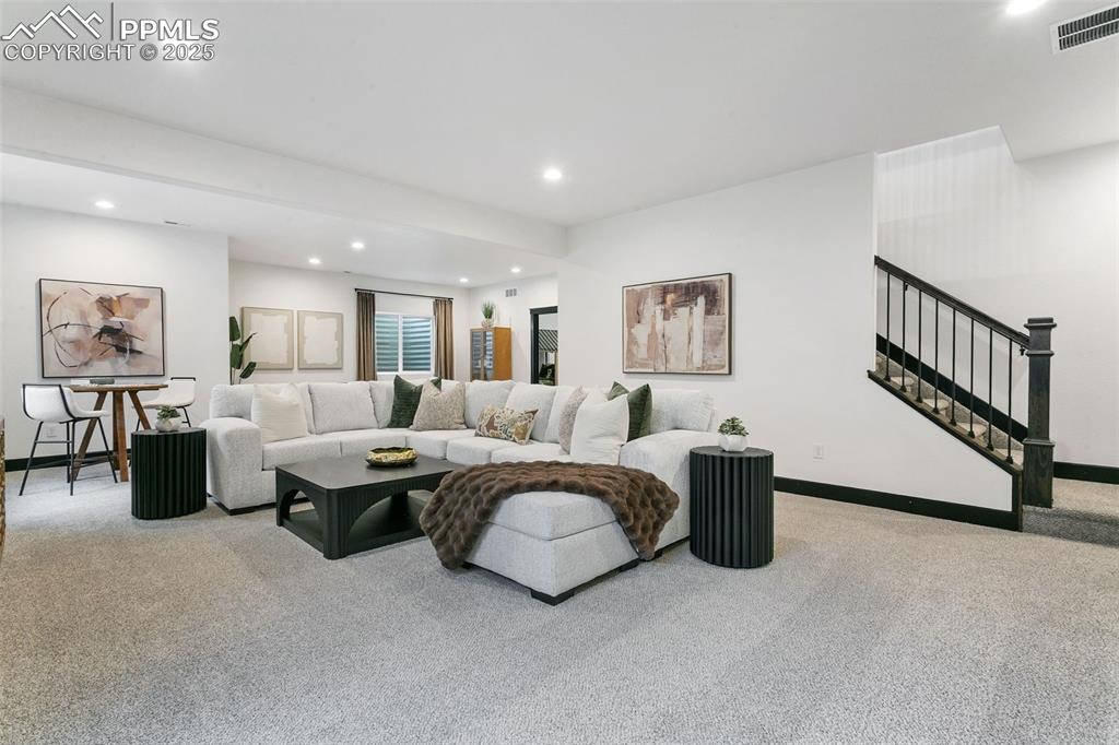 Image 18 of 22: Carpeted living area featuring recessed lighting and stairway