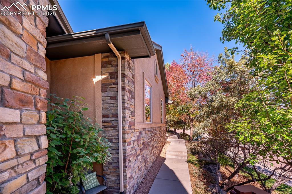 Image 39 of 47: View of side of home featuring stone siding and stucco siding