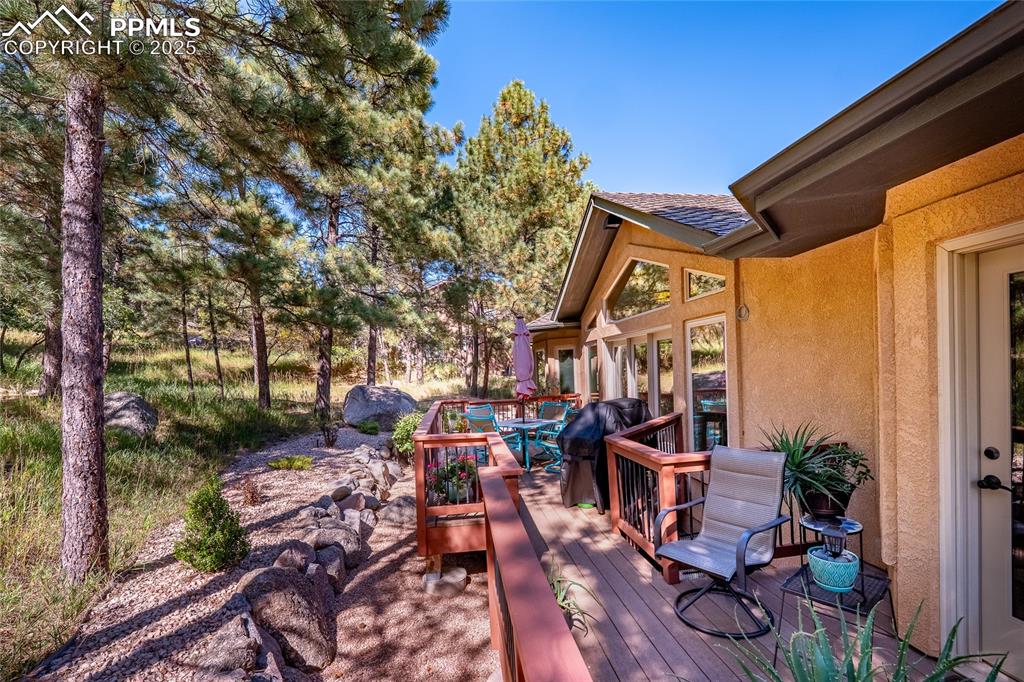 Image 42 of 47: Wooden deck with area for grilling and outdoor dining space