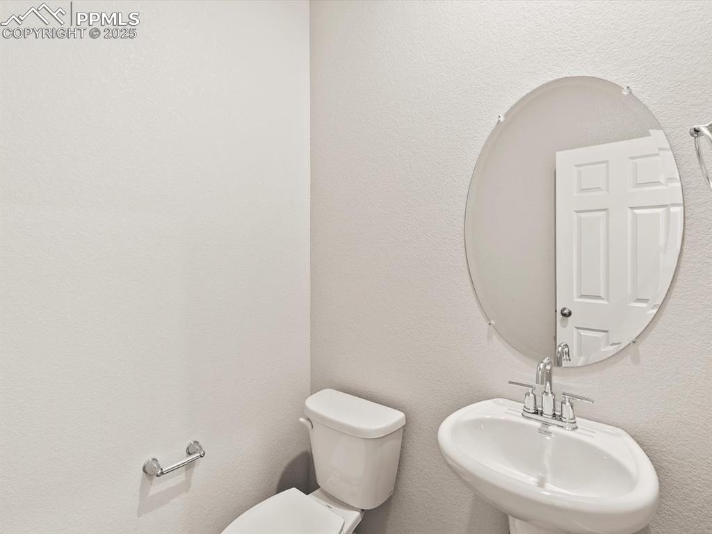 Image 10 of 23: Half bath featuring a textured wall and a sink