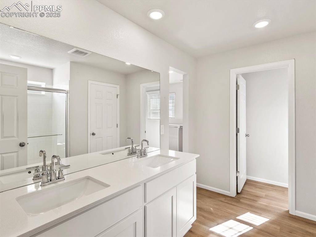 Image 17 of 23: Full bath with a stall shower, light wood-type flooring, double vanity, and