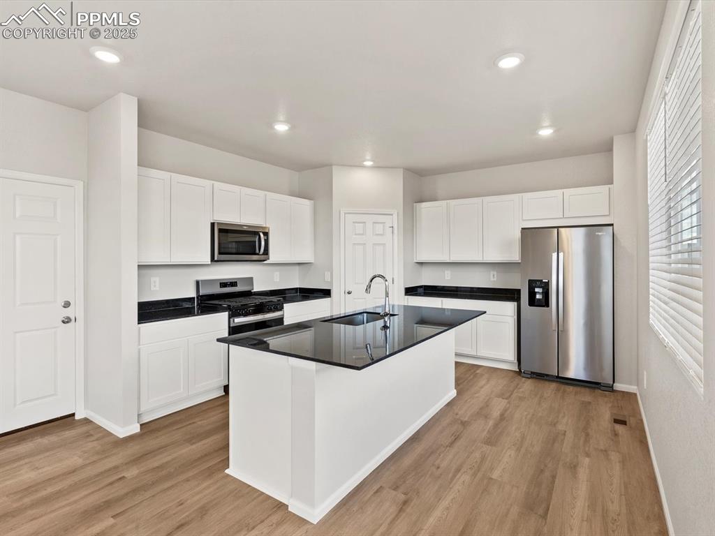Image 7 of 23: Kitchen featuring appliances with stainless steel finishes, white cabinetry