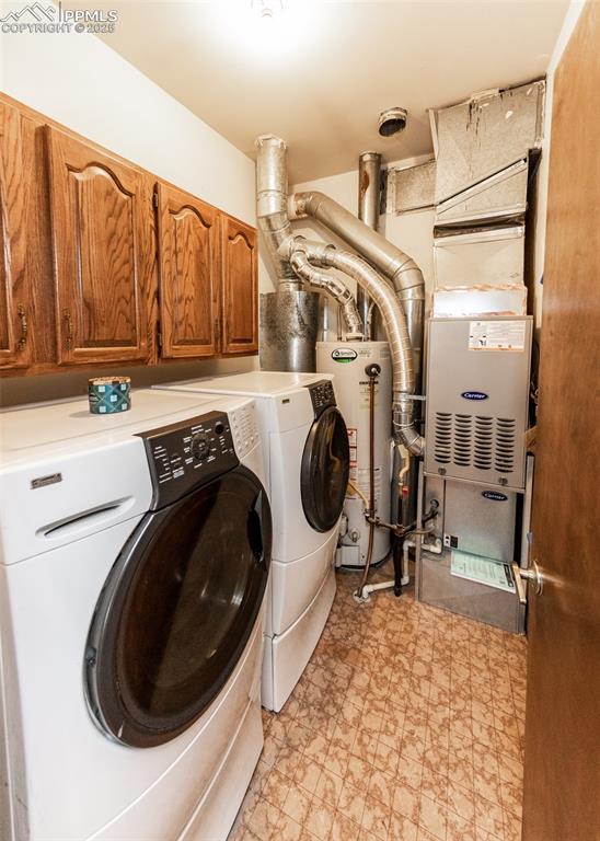 Image 24 of 37: Washroom featuring separate washer and dryer, cabinet space, light flooring