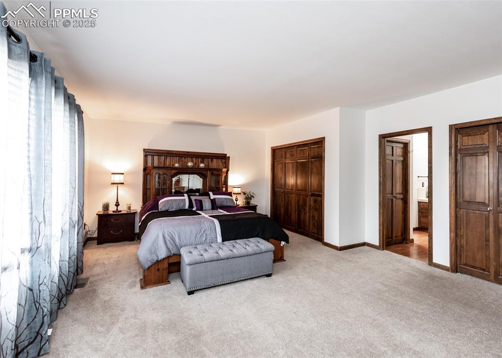 Image 26 of 37: Master bedroom with two large closets entering into the bathroom