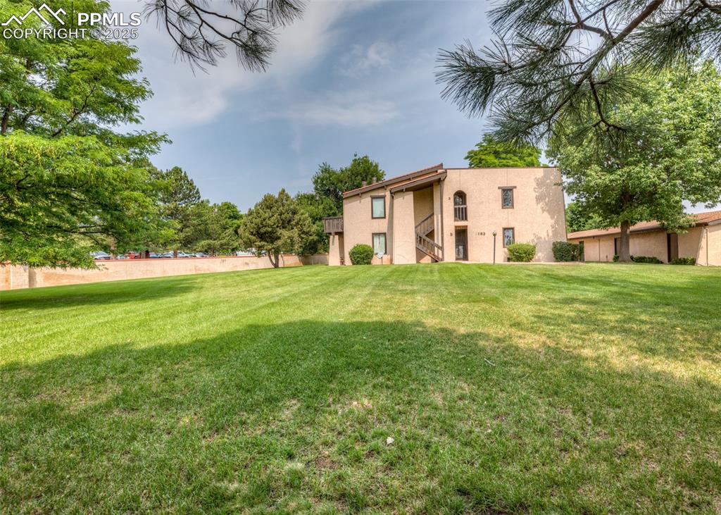 Image 3 of 37: View of green lawn in front of condo