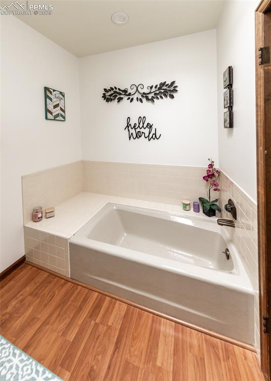 Image 30 of 37: Mater bathroom with a garden tub and wood finished floors