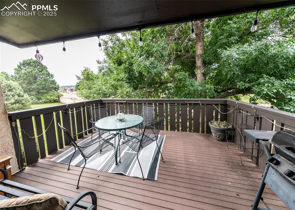 Image 34 of 37: Wooden terrace featuring grilling area and outdoor dining space