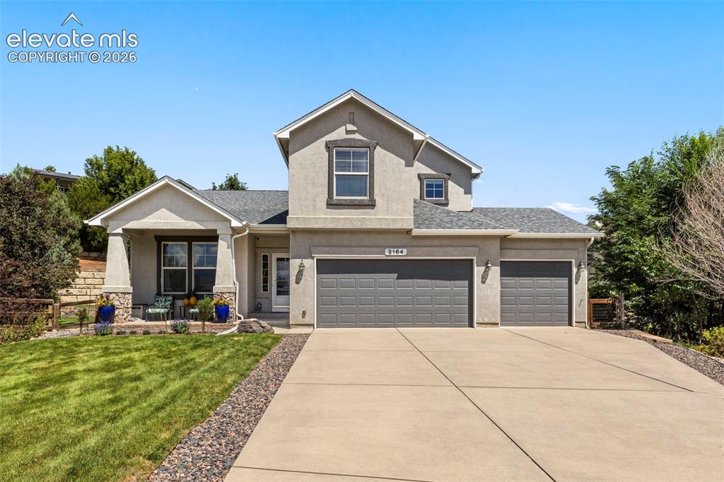 Image 1 of 28: Stucco exterior with stone accents, covered front porch, concrete driveway,