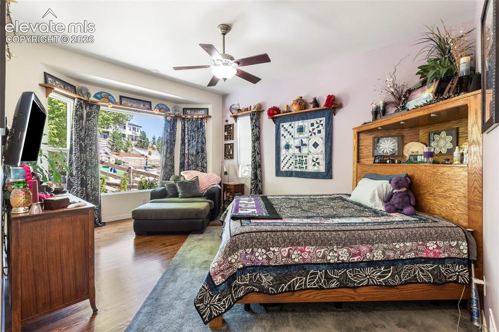 Image 12 of 28: Wood-finish flooring, ceiling fan, built-in headboard shelving, built-in wi