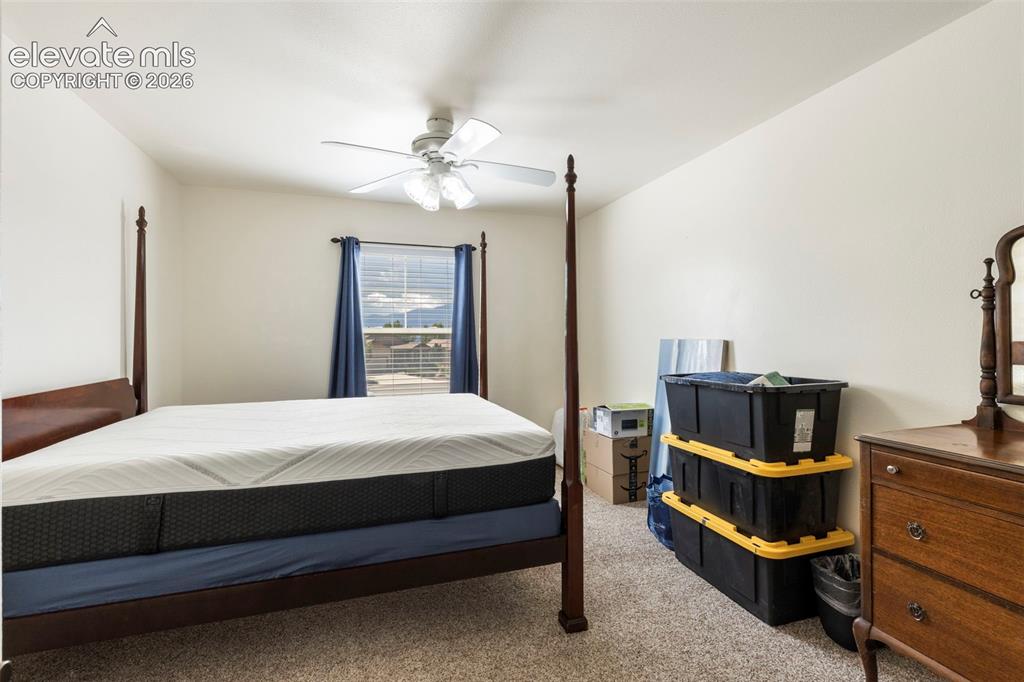 Image 19 of 28: Spacious bedroom featuring a four-poster bed frame, ceiling fan with light 