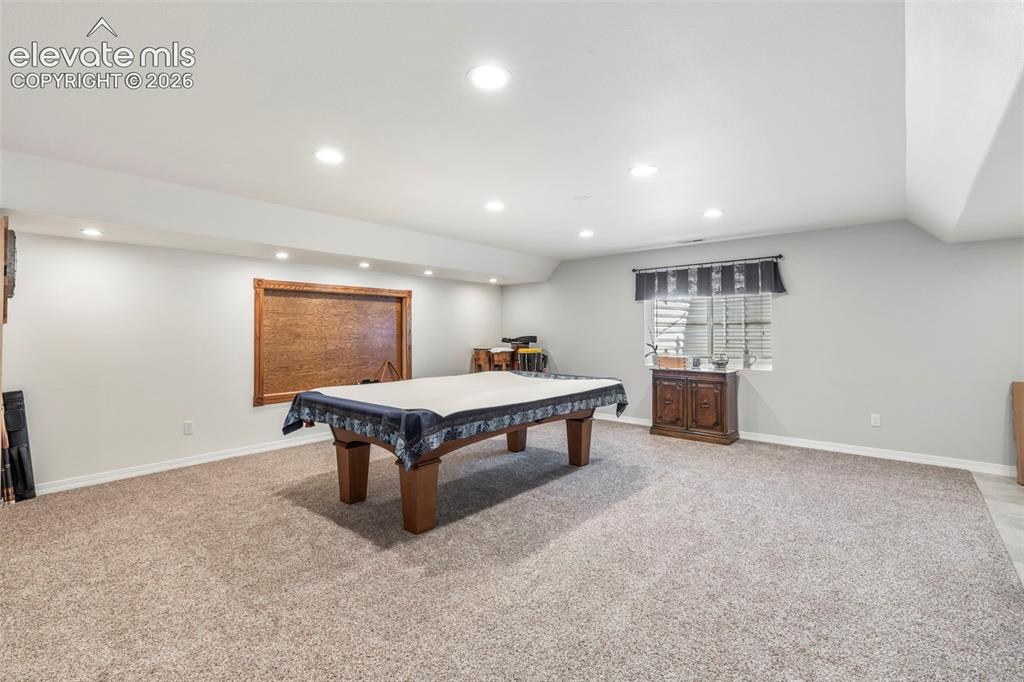 Image 20 of 28: Spacious room featuring recessed lighting, a large window with blinds, and