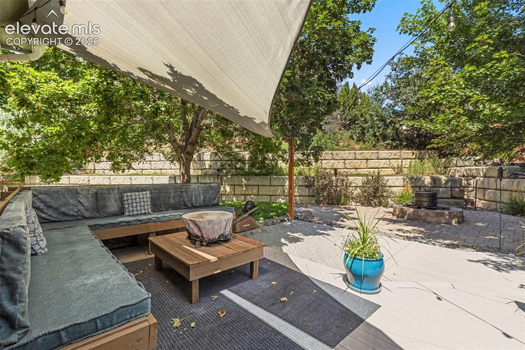 Image 27 of 28: Private outdoor living space with a shade sail, built-in bench seating, woo