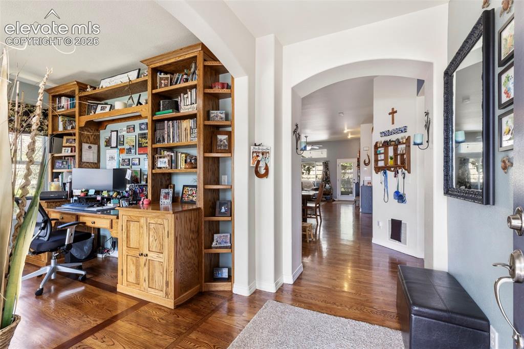 Image 3 of 28: Hardwood-finish flooring, built-in custom wood cabinetry, arched entryway,