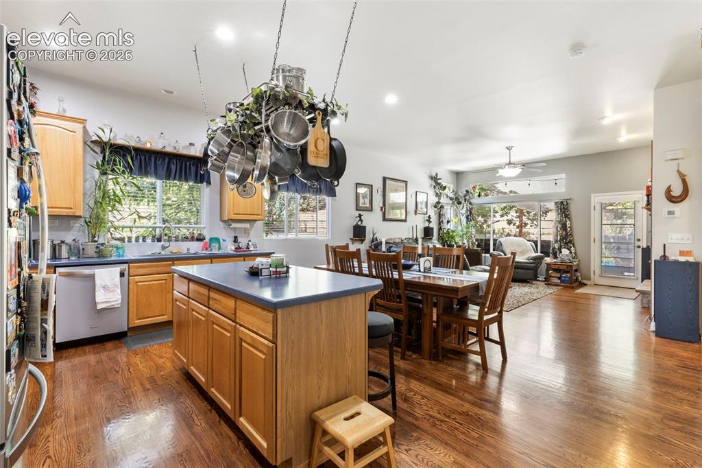 Image 5 of 28: Expansive kitchen featuring wood-finish cabinetry, a central island with a